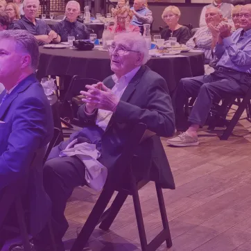 Photo shows a group of people at a dinner